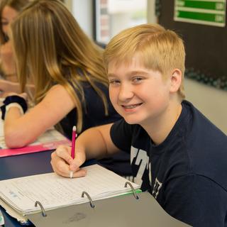 middle school student working on class assignment at table