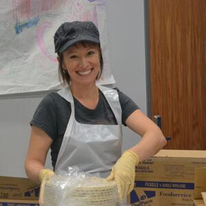 woman smiling in front of a stack of unbaked pie shells